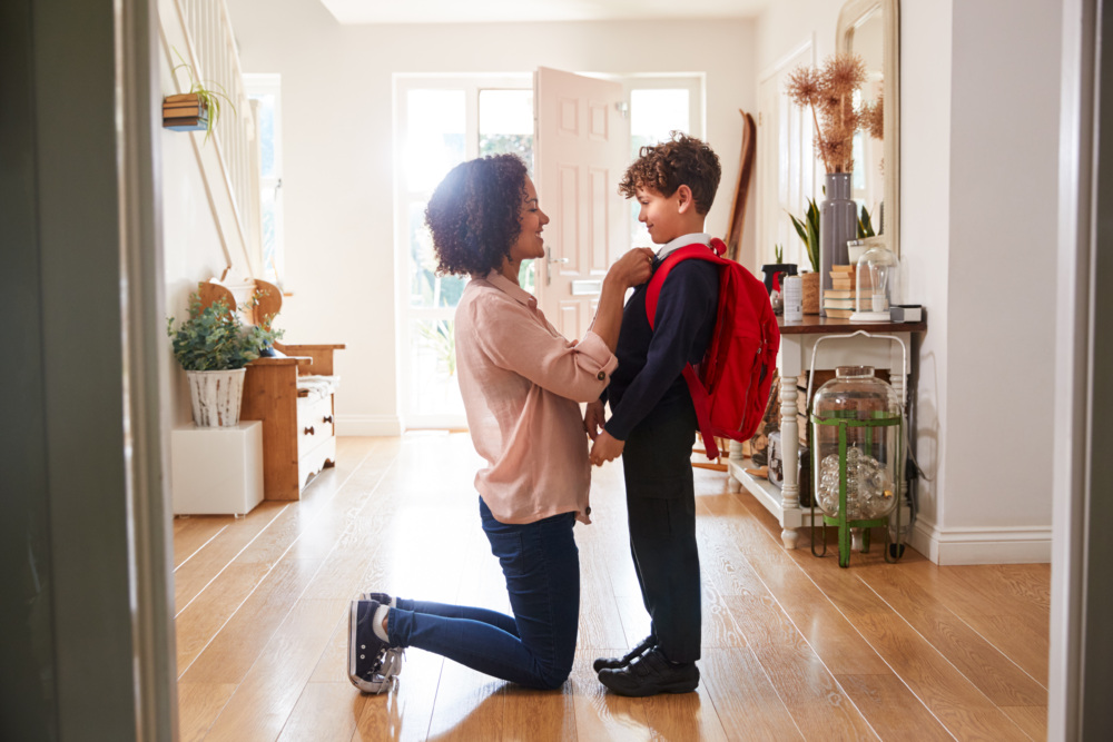 Single Mother At Home Getting Son Ready For First Day Of School
