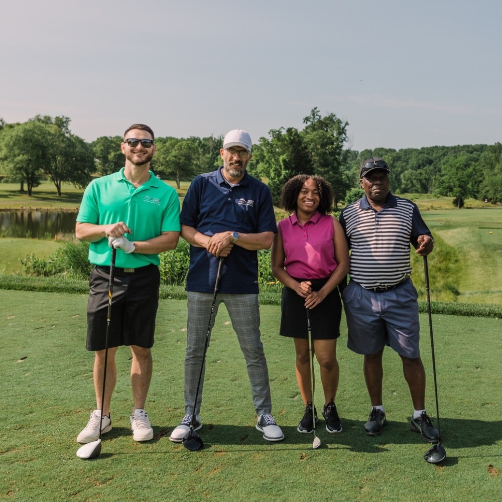 Foursome smiling at Paths for Families Golf Tournament 2023