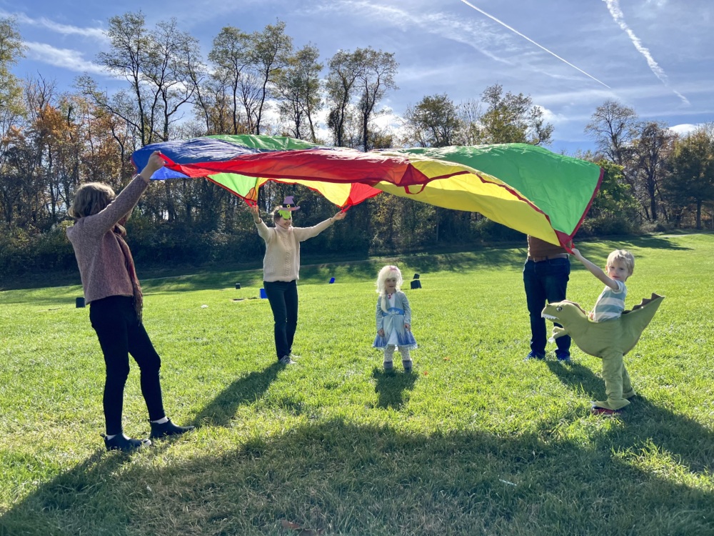 Families playing with parachute at Fall Family Day 2022