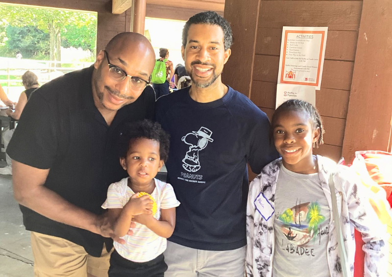 A family smiles at an outdoor picnic