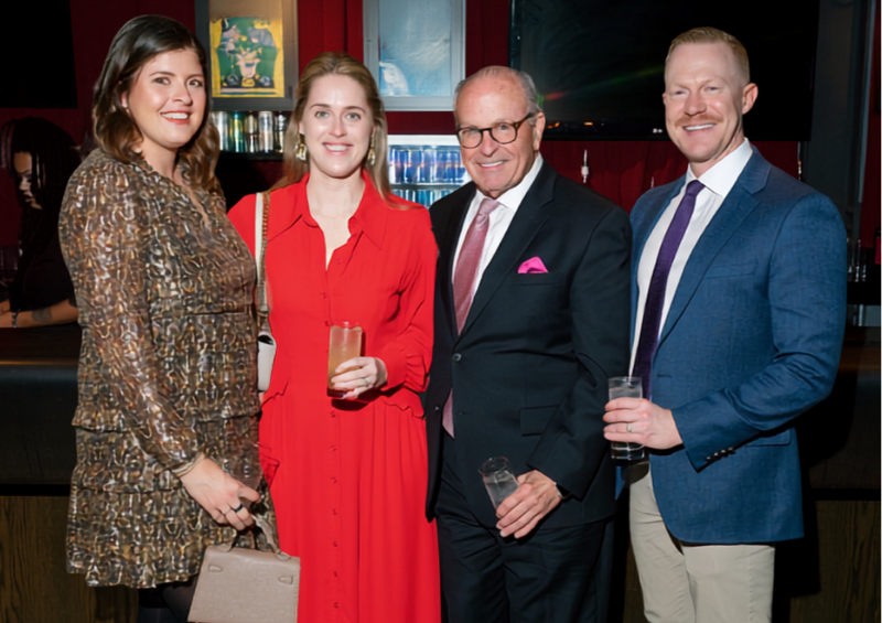 A group of people smile during cocktail hour at a gala