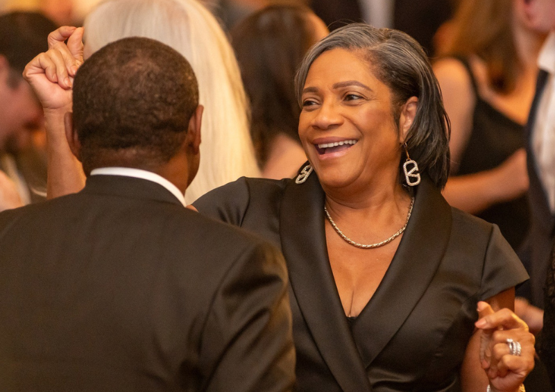 A duo happily smiling and dancing at a gala