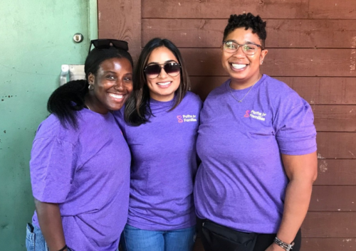 Staff members smiling for a photo while wearing purple paths for families shirts