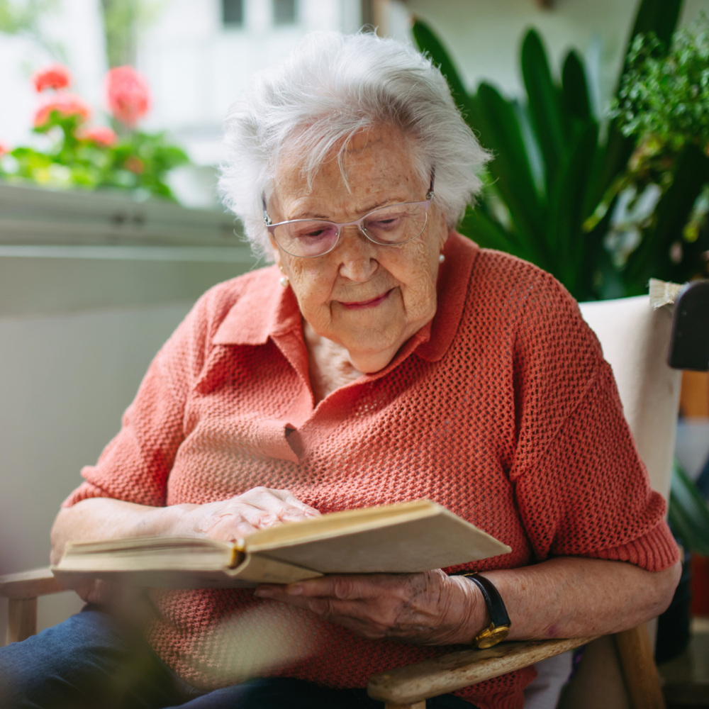 Senior lady reading book at balcony.