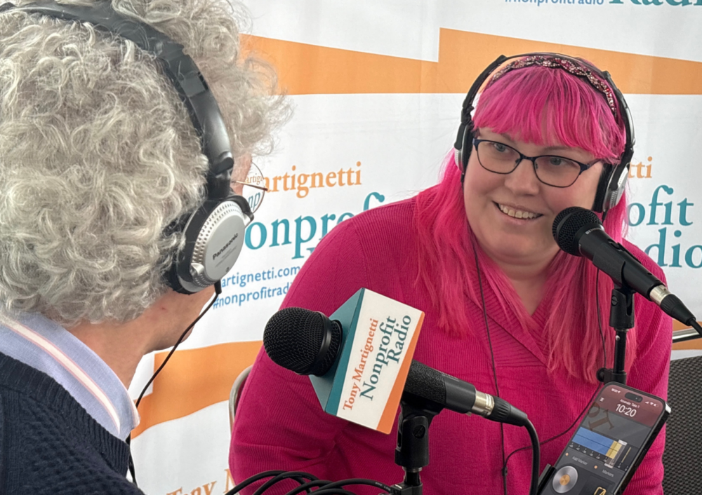 Amanda Bache speaks into a microphone while being interviewed on Nonprofit Radio
