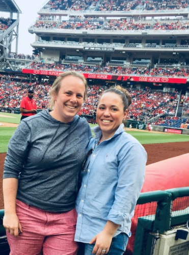 A couple stands and takes a picture at a sports arena